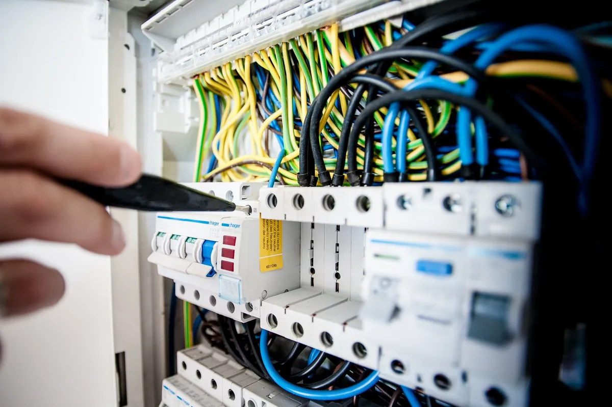 Electrician lucrând la un tablou electric cu siguranțe automate